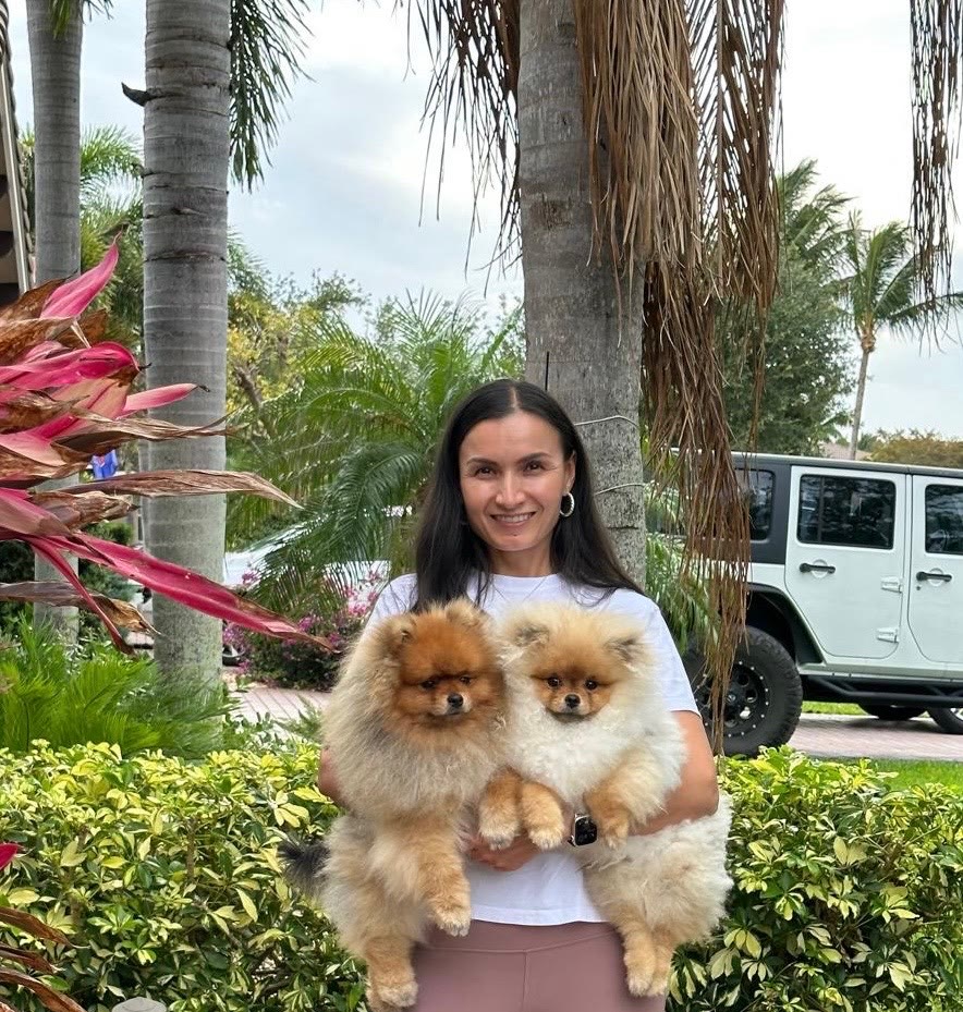 Zarina holding Mocha and Mochi outside under palm trees